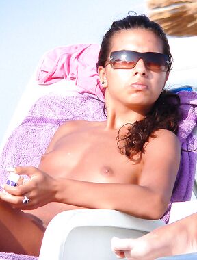 Lounging Topless on a Sandy Beach Chair With a Purple Towel