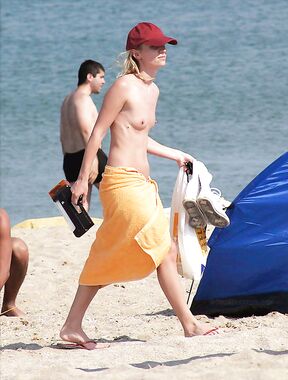 . A lady absorbed in the scenery while enjoying the warm rays in a relaxed topless fashion.