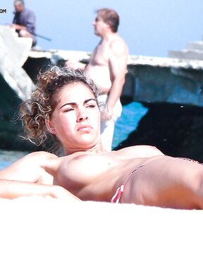 Descanso topless no cais de betão com ondas a rolar